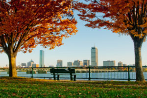 A bench overlooking the Charles in autumn; Back Bay is visible across the river.